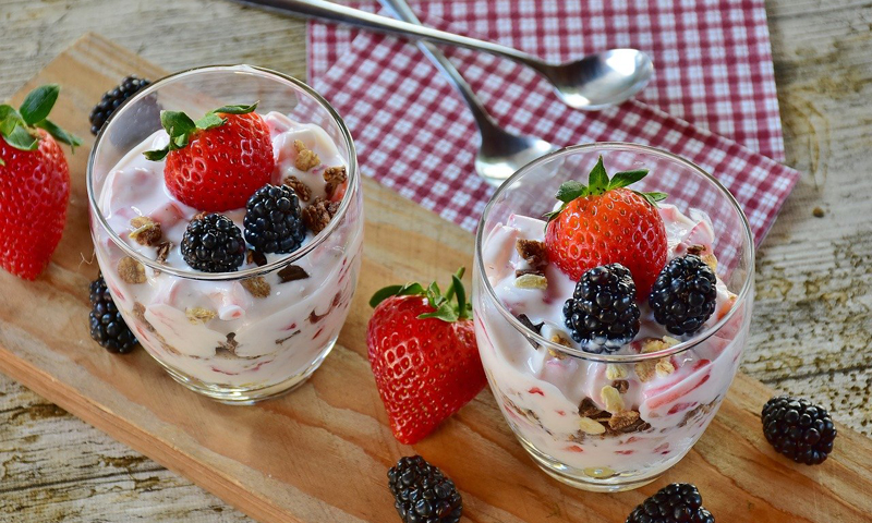 A cup with red berries and soft white cheese